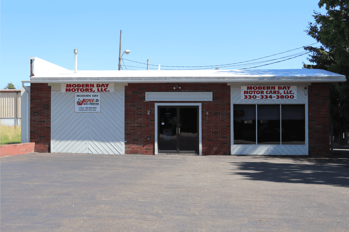 Modern Day Muffler & Brakes at 218 S Lyman St in Wadsworth, Ohio — a single-storey brick shop with white bay doors and a gravel lot out front